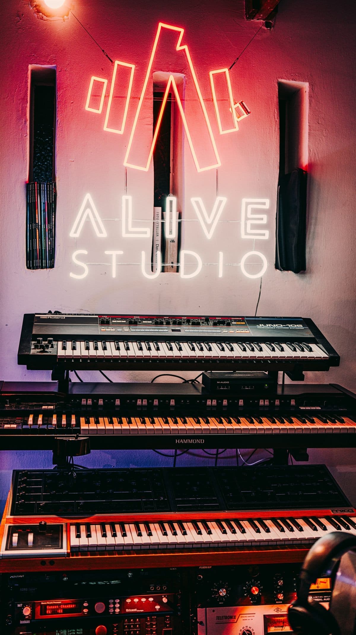 The Alive neon sign over the synth stack