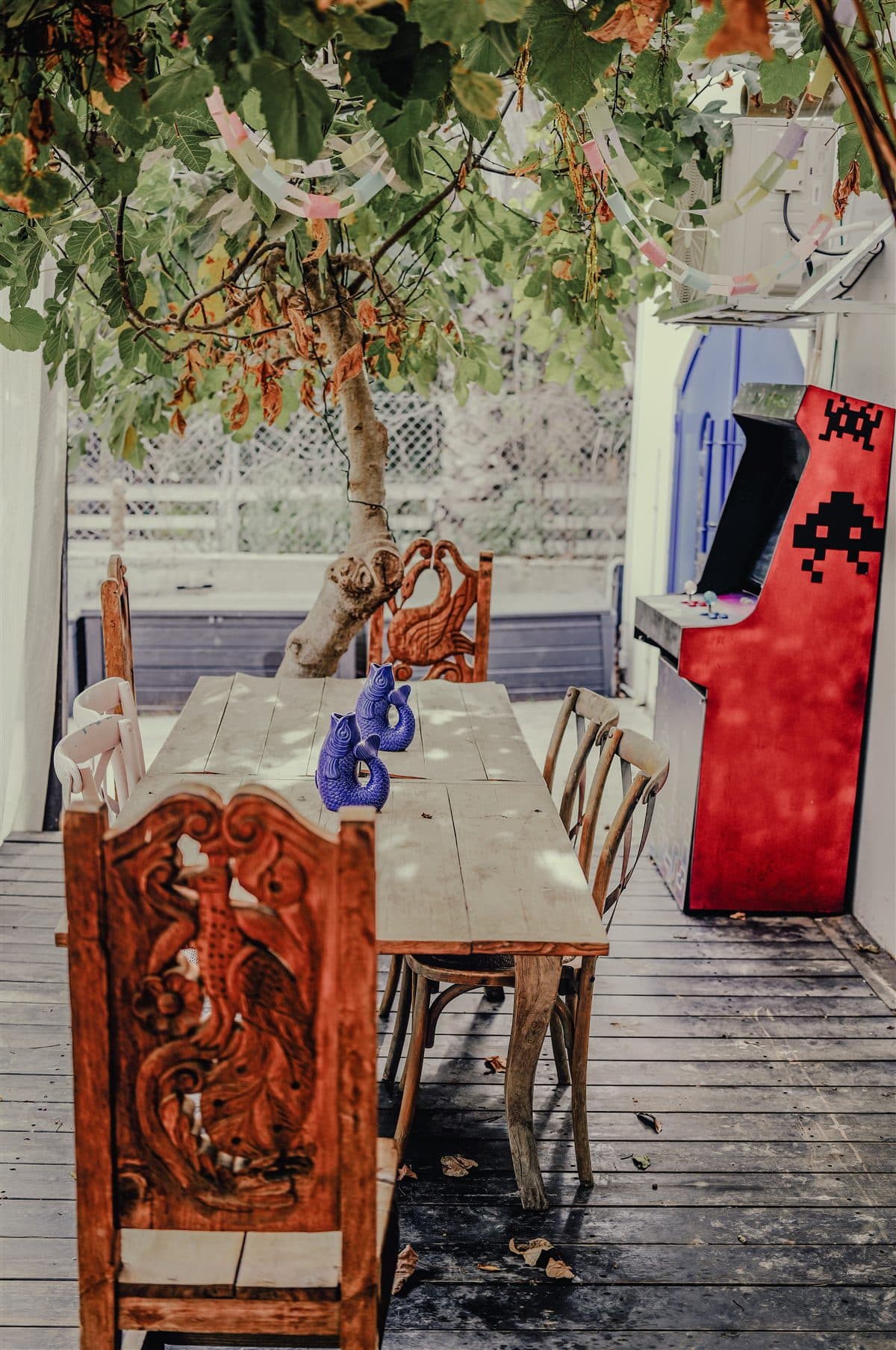 The covered patio with carved chairs and the red arcade